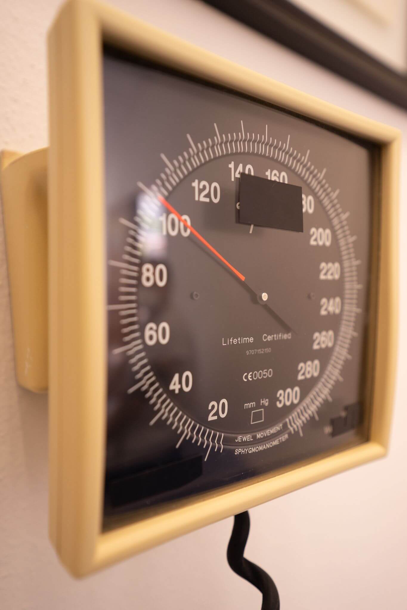 Vintage pressure gauge on wall, showing dial and numbers clearly marked.